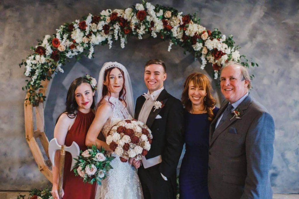 Bride and groom with family under floral arch at Castle Waterford wedding venue