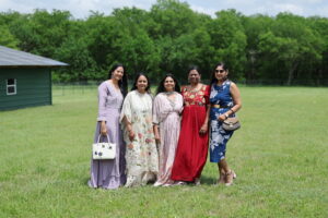 Group of women in traditional Indian attire posing together on lawn at Castle Waterford