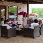 Group of people relaxing and chatting in an outdoor lounge seating area with umbrellas