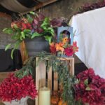 Wedding décor display with candles, greenery, and red floral arrangements at Castle Waterford