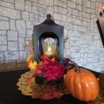 Autumn themed wedding décor with lantern, pumpkin, and floral arrangement at Castle Waterford
