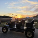 Vintage golf cart at sunset near Castle Waterford with scenic golden sky backdrop