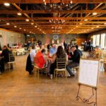 Guests seated at round tables during wedding reception at Castle Waterford indoor hall