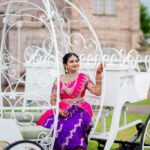 Woman in traditional Indian attire sitting in decorative carriage at Castle Waterford outdoor setting