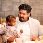 Man holding a child during wedding celebration at Castle Waterford indoor setting