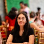 Woman with glasses smiling during wedding event seated at banquet table at Castle Waterford