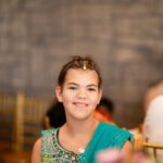 Young girl smiling during wedding celebration at Castle Waterford indoor setting