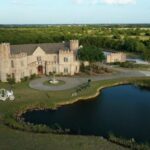 Aerial view of Castle Waterford with lake, courtyard, and scenic landscape surroundings