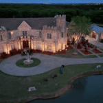 Aerial view of Castle Waterford with illuminated courtyard and lakeside surroundings at dusk