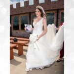 Bride holding bouquet and walking in wedding gown at Castle Waterford outdoor area