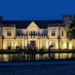 Castle Waterford illuminated at night with reflection in water showcasing luxury wedding venue