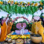 Haldi ceremony with bride seated under floral canopy and guests celebrating at Castle Waterford