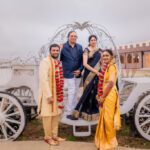 Guests in traditional Indian attire posing with vintage carriage at Castle Waterford wedding celebration