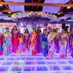 Group of women dancing on illuminated LED dance floor at a colorful wedding celebration