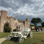 Vintage white carriage in front of Castle Waterford with dramatic cloudy sky and wedding setup