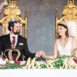 Bride and groom seated on royal chairs holding hands at Castle Waterford wedding ceremony