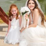 Bride with young girl in white dresses smiling during wedding photoshoot at Castle Waterford