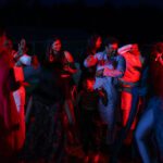 Guests dancing under colorful lights during wedding party at Castle Waterford reception