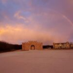 Castle Waterford entrance gate during sunset with colorful sky and open landscape