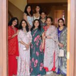 Group of women posing together indoors in traditional Indian outfits during a celebration