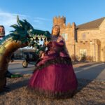 Woman in elegant gown posing near dragon sculpture at Castle Waterford outdoor setting