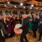 Guests dancing energetically with drum performance during wedding reception at Castle Waterford