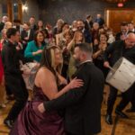 Couple dancing with guests and live dhol music at wedding reception at Castle Waterford