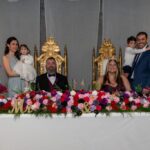 Couple seated on golden chairs with family at Castle Waterford wedding ceremony with floral decorations