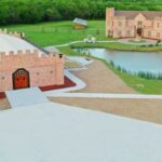 Castle Waterford estate view with lakeside building, pathways, and scenic green surroundings