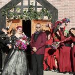 Bride and groom celebrating with guests holding flowers at Castle Waterford wedding entrance