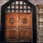 Historic wooden entrance doors of Castle Waterford with detailed carvings and stone frame